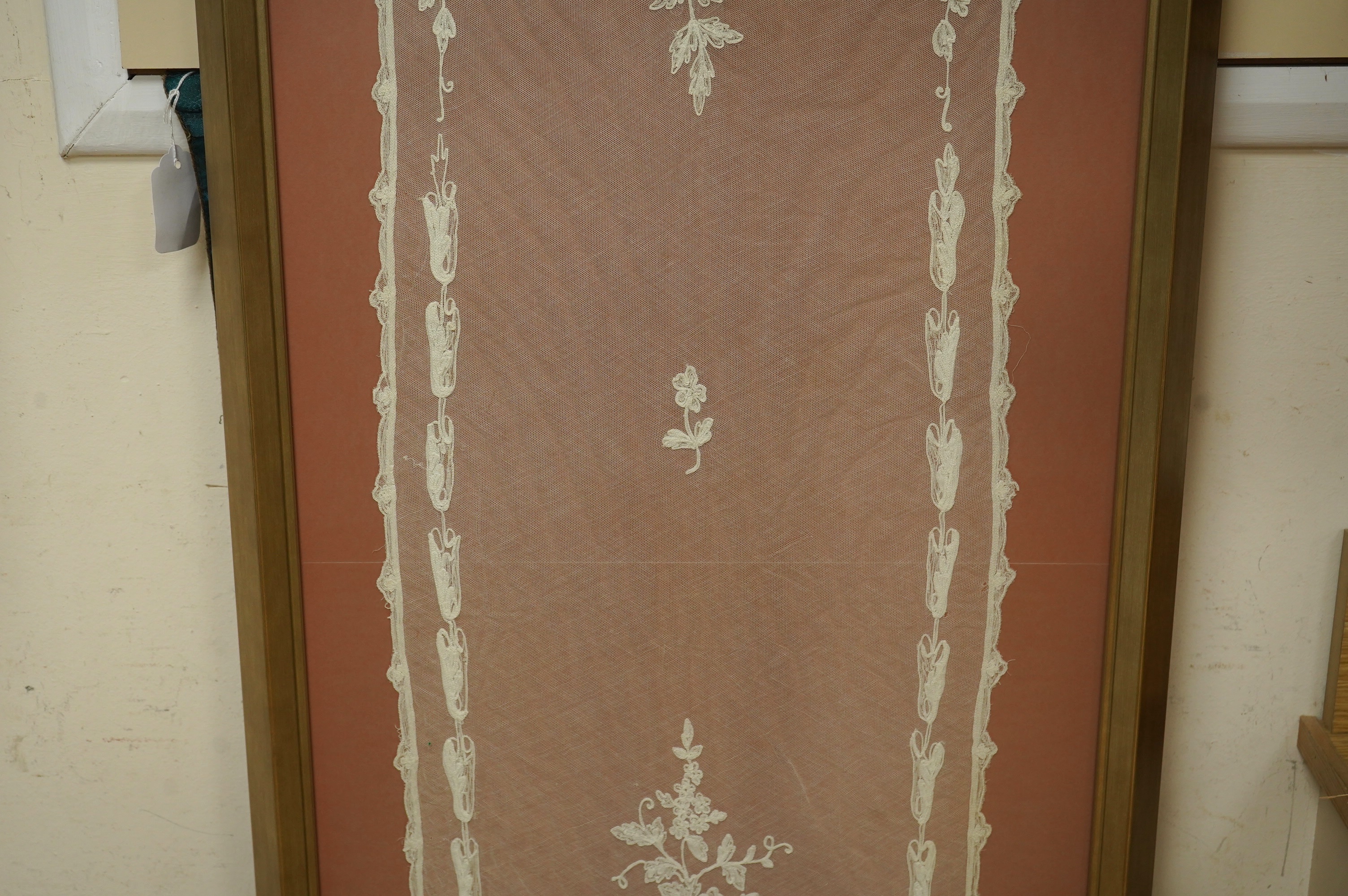 A framed Victorian white work needlerun lace stole with decorative urns and flowers each end, 154cm long x 33cm wide. Condition - has small darns to net one end, otherwise good.